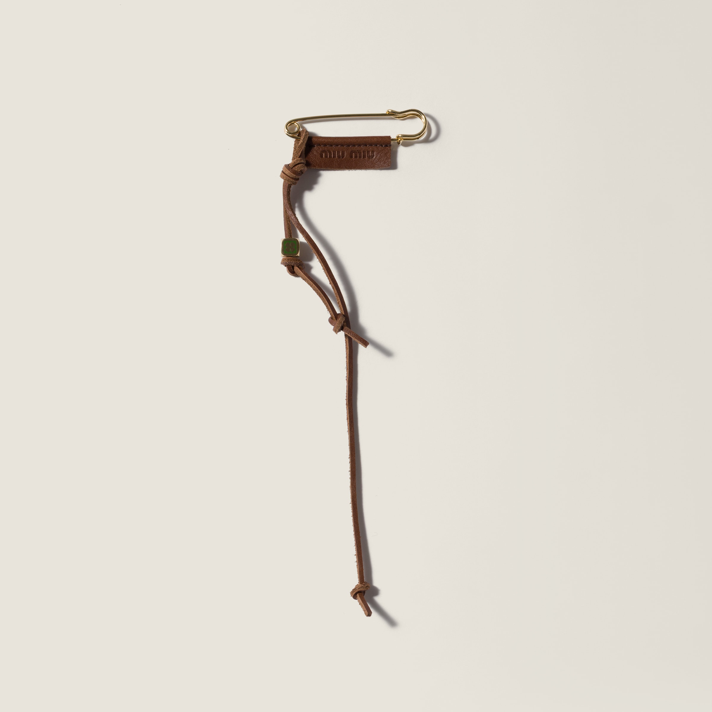 Metal and leather safety pin brooch from Miu Miu - $380